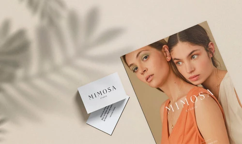 Mimosa identity applied to printed cards and a fashion publication mockup